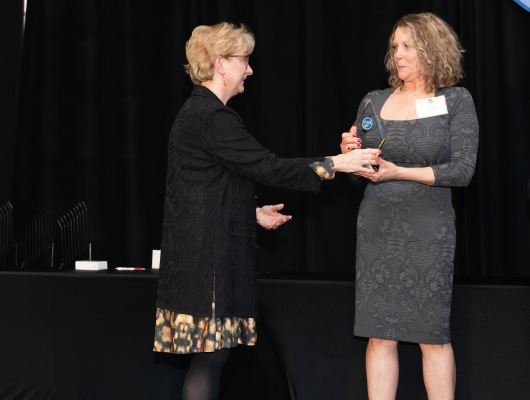woman giving another woman an award