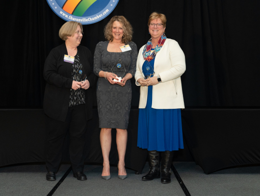 three women holding awards