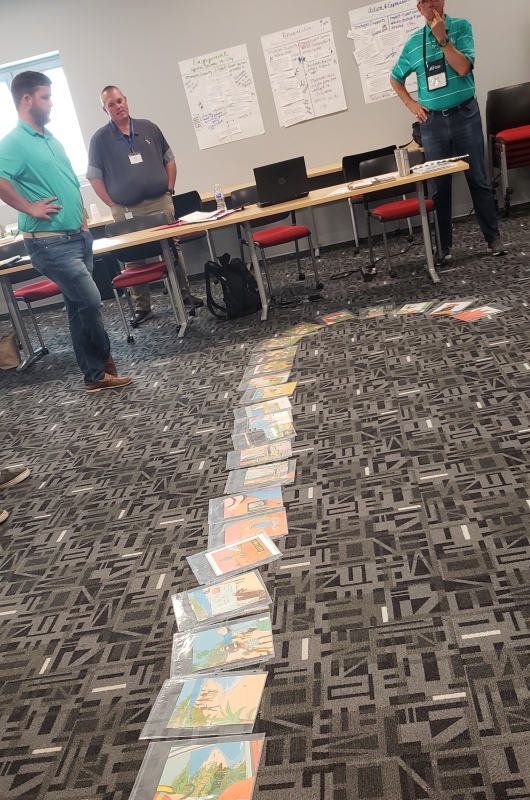guys standing in front of line of papers on floor