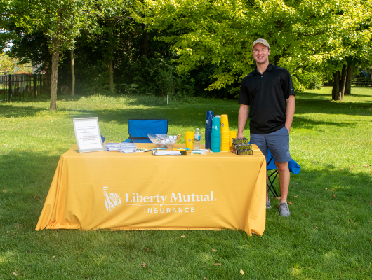 man standing next to Liberty Mutual table