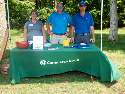 people standing behind Commerce Bank table