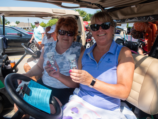 women sitting in golf cart