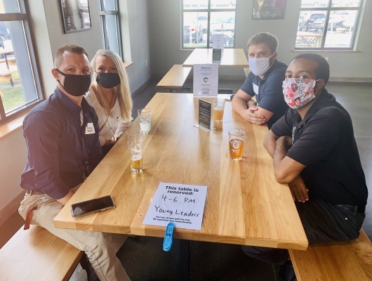 people sitting at table wearing masks